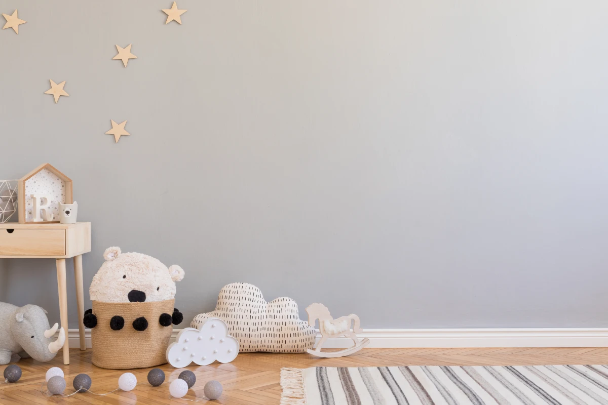 Невеликий килим, м’які іграшки та дерев’яні елементи, як-от столик або зірочки на стіні – це квінтесенція скандинавського стилю на дитячому рівн